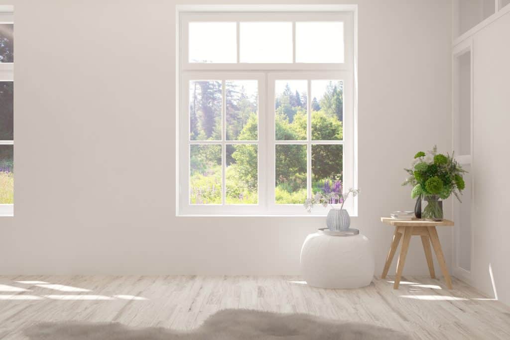 Stylish empty room in white color with summer landscape in window. Scandinavian interior design. 3D illustration