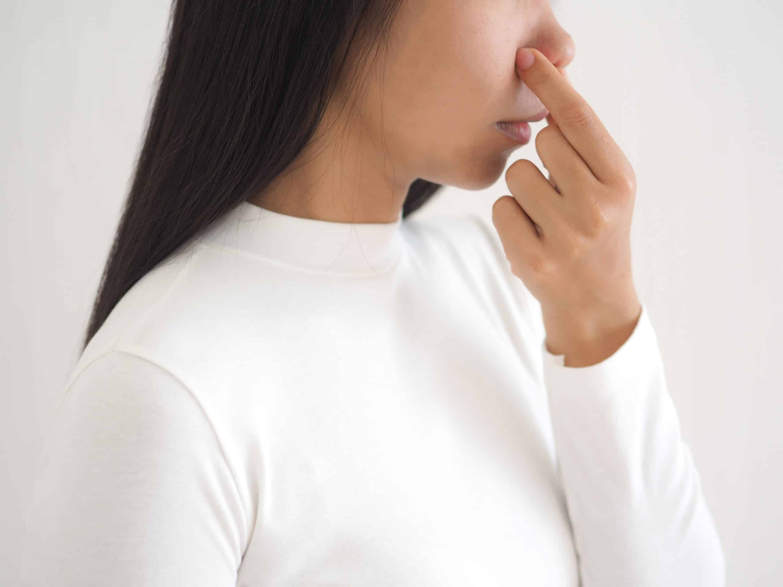 bad smell in nose in asian woman and cause of nasal polyps or sinus infection and post nasal drip on white background use for health care concept.